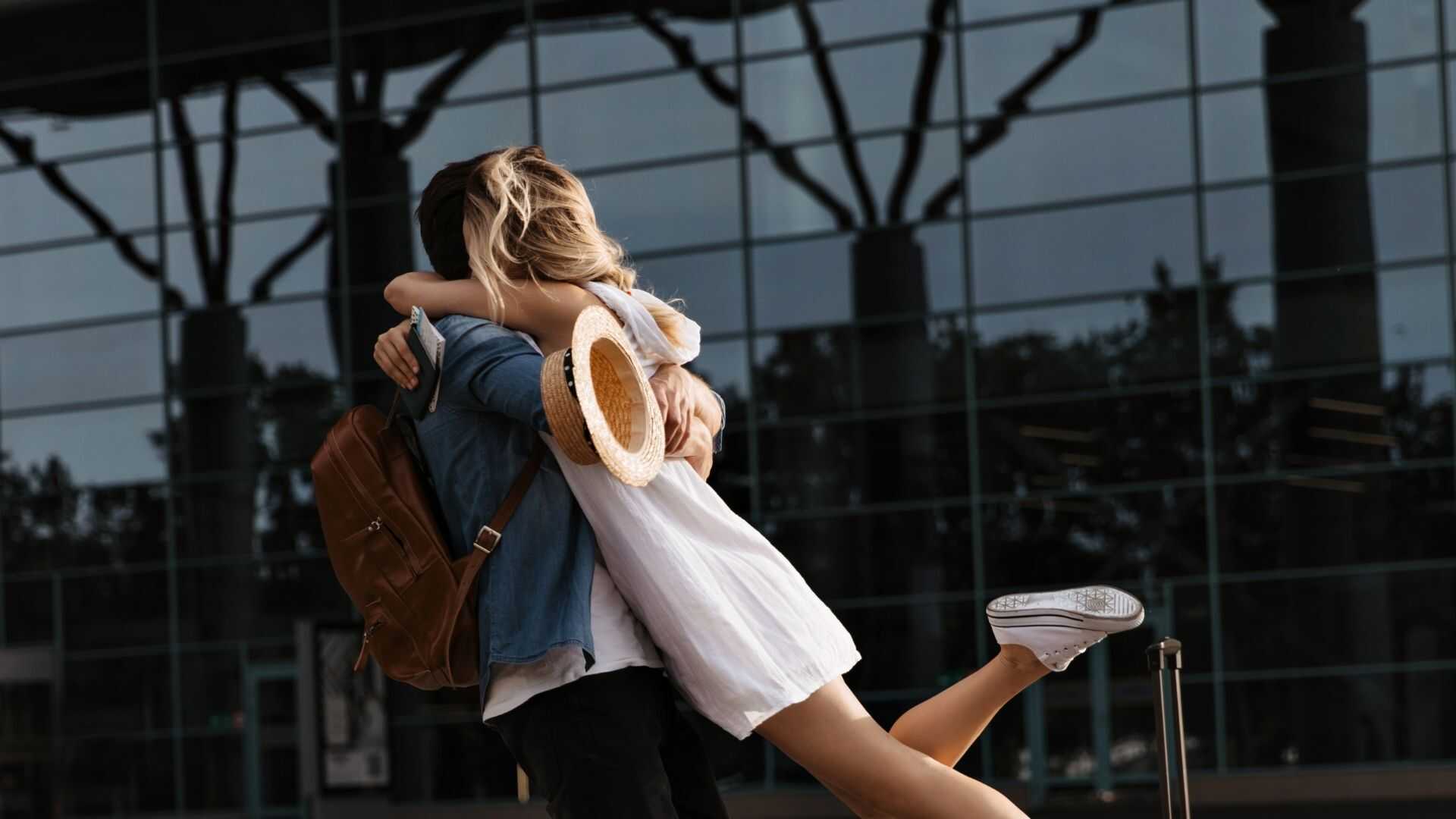 Couple embracing at the airport terminal after arriving on a private charter flight.